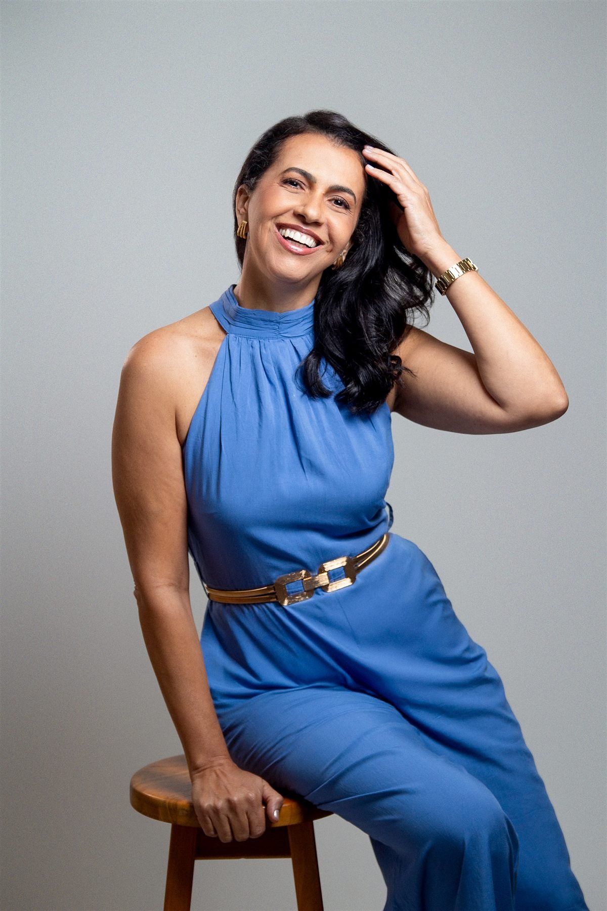 Luana Farias sorrindo em retrato com vestido azul